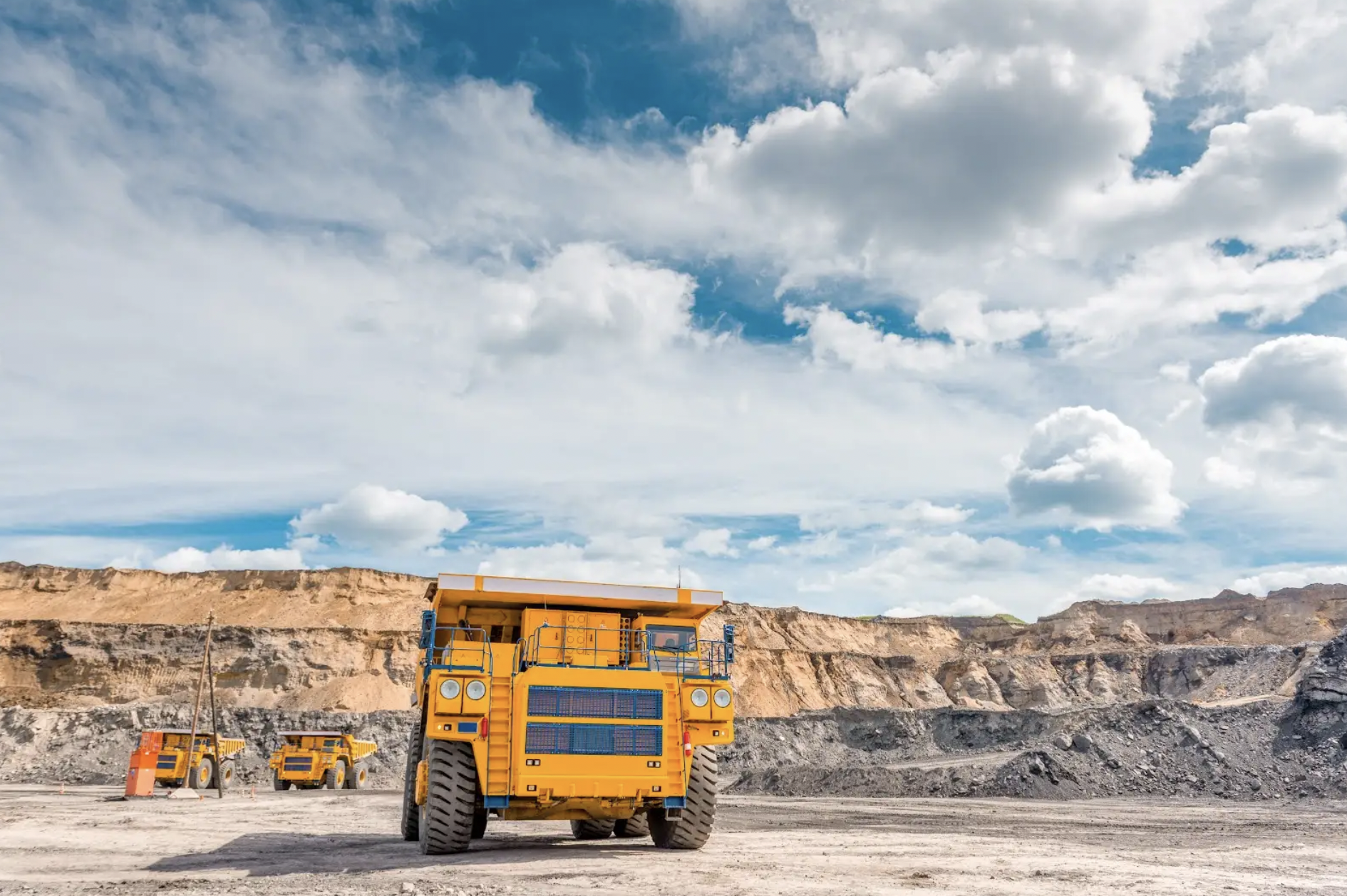 Yellow mining truck in open dirt field