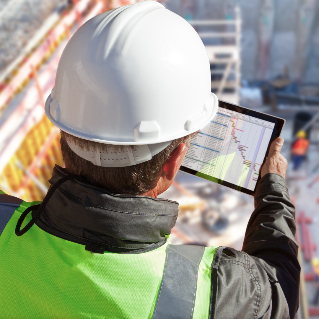 Construction worker in safety gear on tablet at construction site